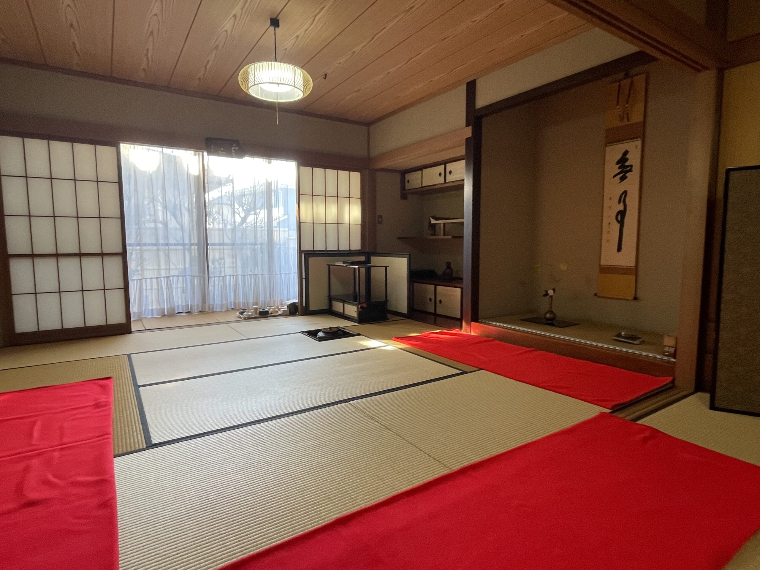 障子、床の間、畳と赤い敷物が見える茶室全景